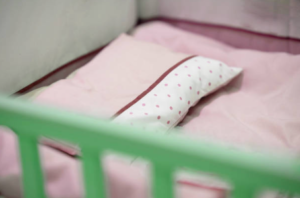 photo of an empty crib with crib bumpers in place